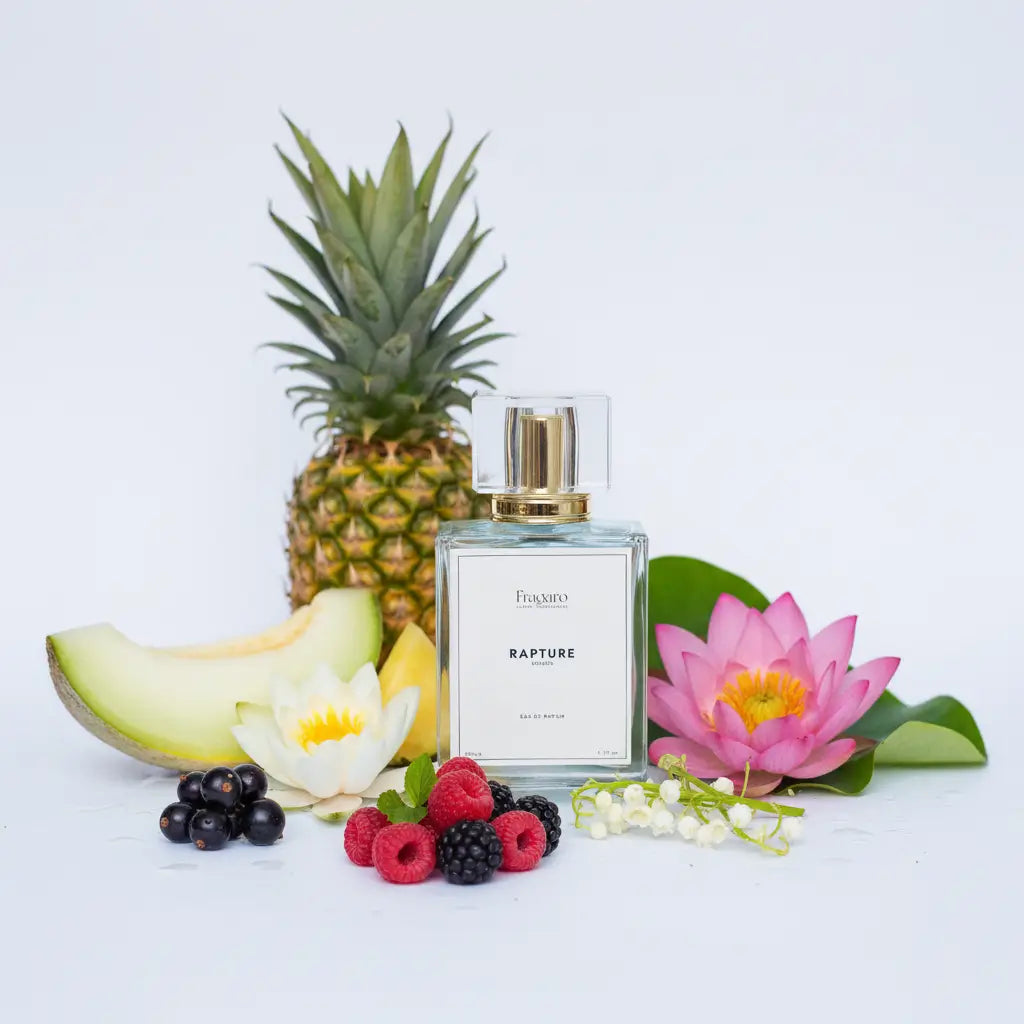 Perfume bottle Rapture with a pineapple, melon, flowers, and berries on a light background