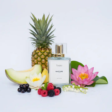 Perfume bottle labeled 'Rapture' with a pineapple, melon, flowers, and berries on a light background